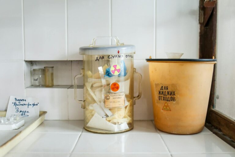 Two containers in a laboratory setting for managing radioactive waste disposal.