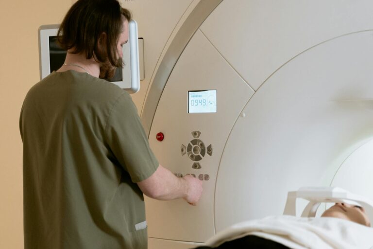 A healthcare worker operates an MRI scanner with a patient in a medical facility.