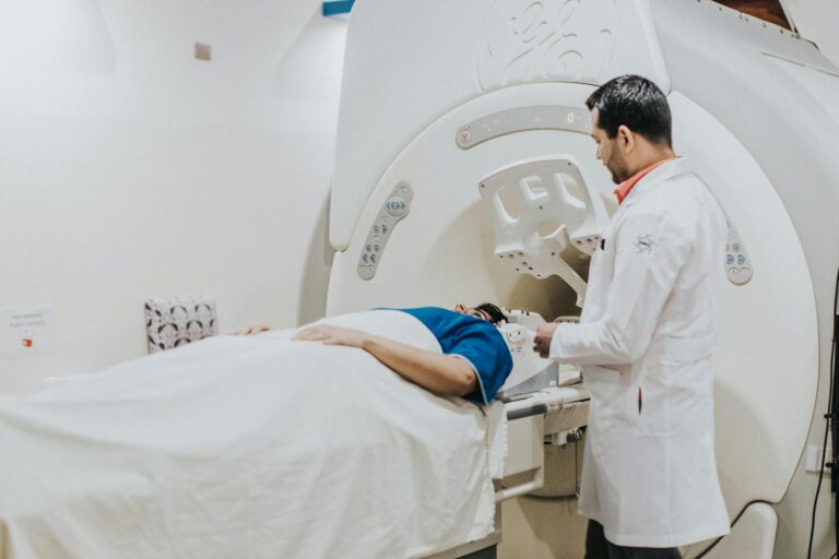Doctor assisting patient in MRI scanner during medical examination in hospital setting.