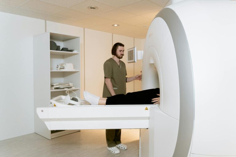 Medical professional assisting a patient during an MRI scan in a hospital setting.