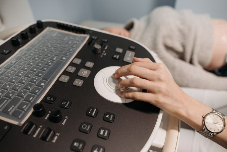 A hand operates medical ultrasound equipment, focusing on healthcare technology.