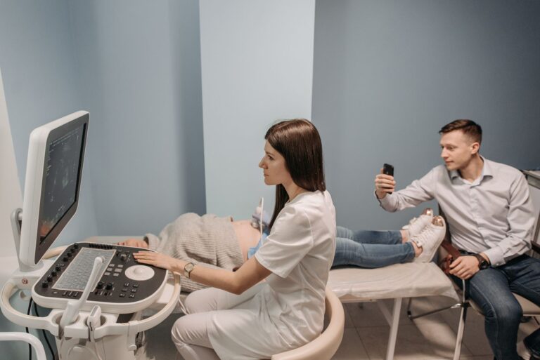 Medical professional conducts ultrasound for expectant couple in clinic.