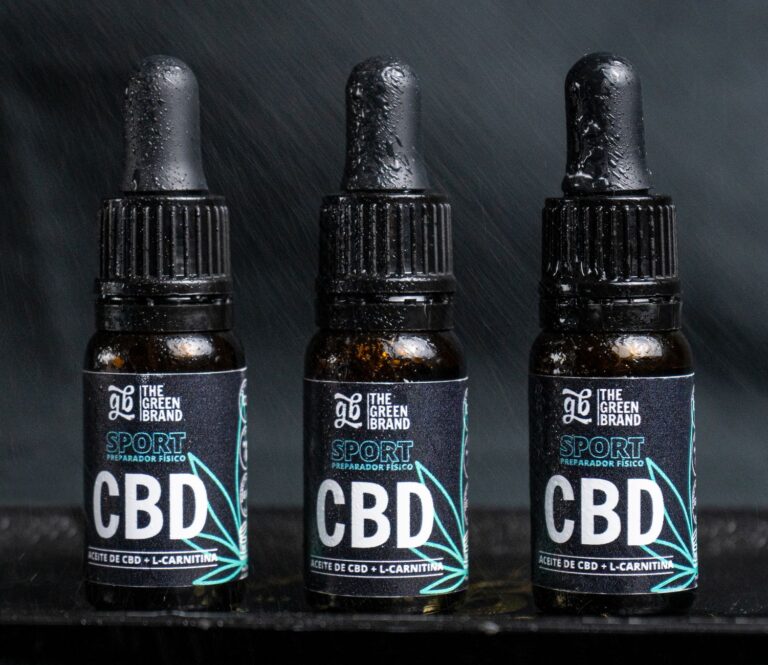 Close-up of three CBD oil bottles labeled for sports recovery and fitness.