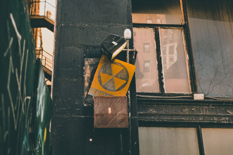 A vintage radioactive warning sign on an urban building wall, exuding a rustic industrial vibe.