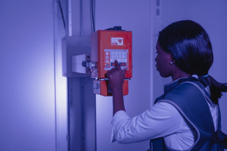 Woman operating medical equipment in a high-tech lab setting.