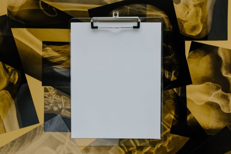 Top view of a blank clipboard on a background of various skeletal x-ray images, ideal for medical themes.