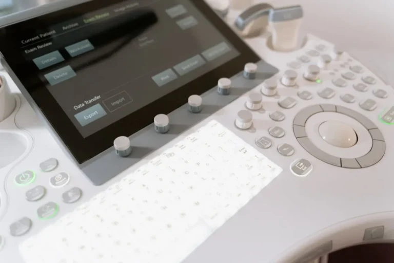 Detailed view of a medical ultrasound machine control panel with buttons and screen.