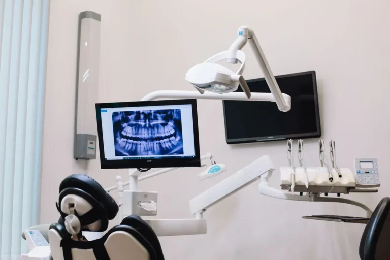 A modern dental office setup featuring an X-ray display on a monitor and advanced dental equipment.